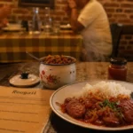Restaurant ile de la reunion : rougail saucisse et riz, table en bois.